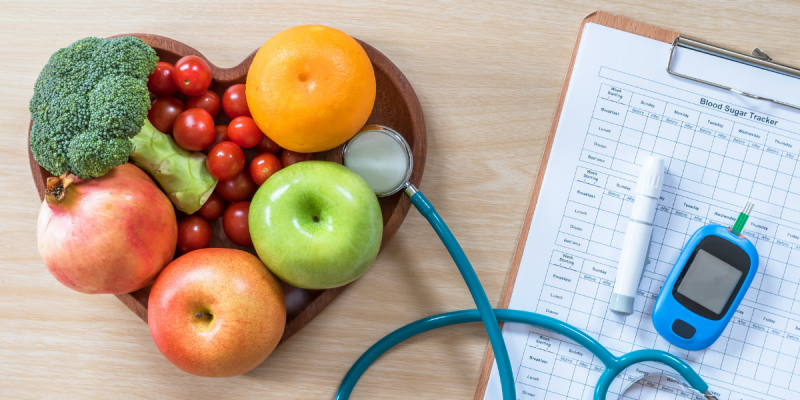 a bowl of fruit and a blood sugar tracking log